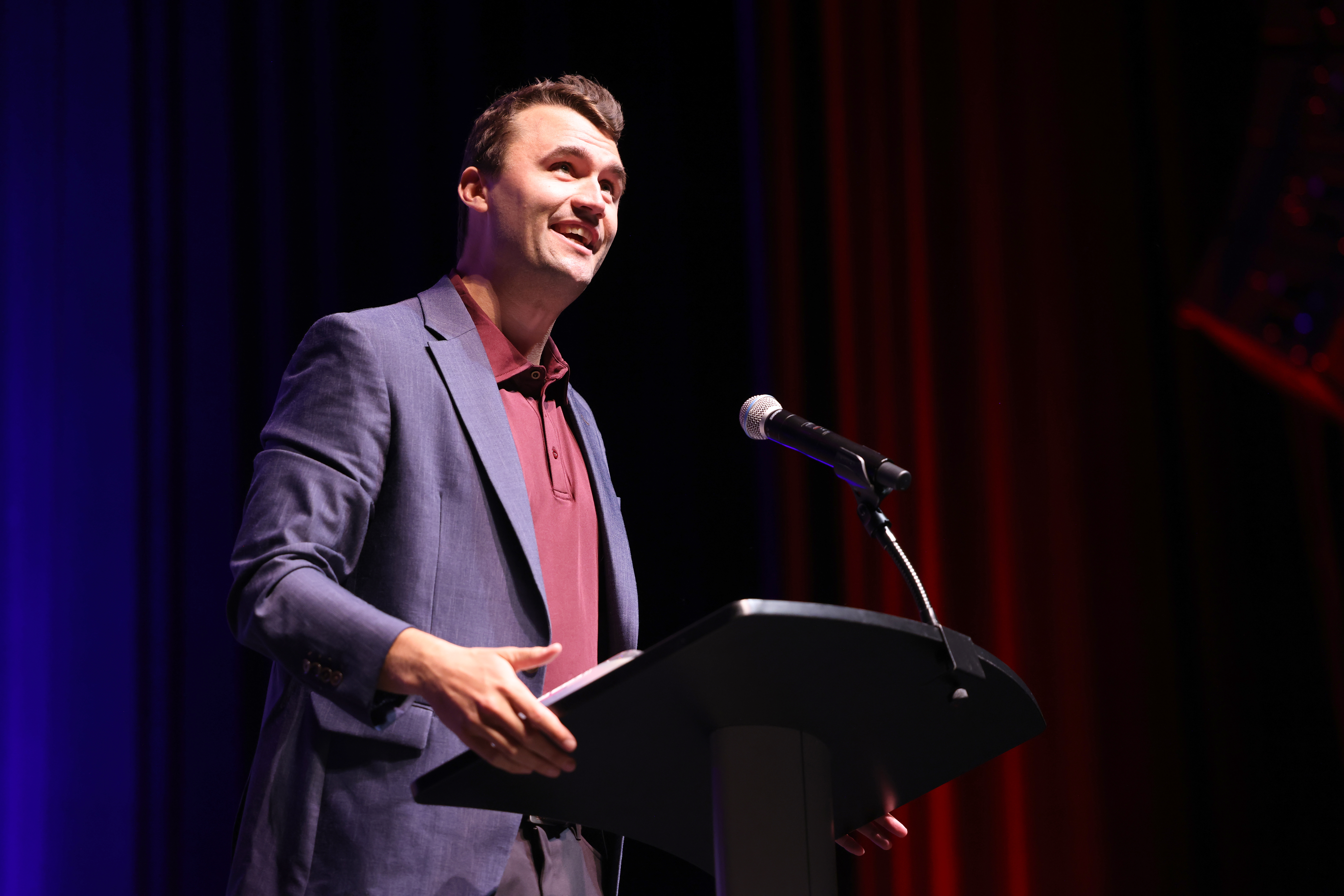 Charlie Kirk speaking at a podium.